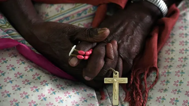 Woman wey dey hold rosary