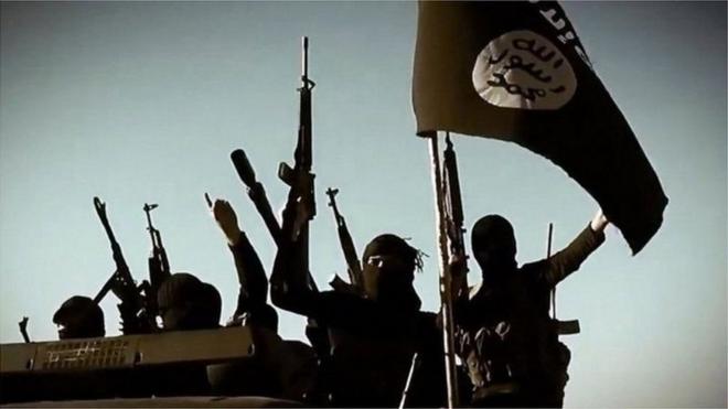 إرهابيون يرفعون علم تنظيم دول الإسلامية