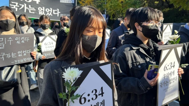 Protesters near the site of the crush in Itaewon held banners that read: "At 6:34 the country was not there [for the victims]"