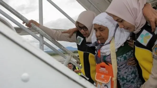 Seorang calon jemaah haji dipapah petugas saat keberangakatan sebelum pandemi covid-19.