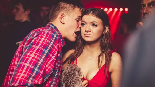 Dos amigos hablando en una discoteca