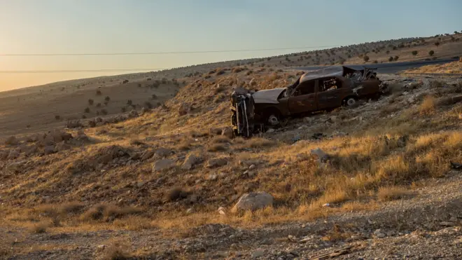 辛賈爾鎮外一一輛被焚毀的汽車與逃難村民遺留的衣服（資料圖片）