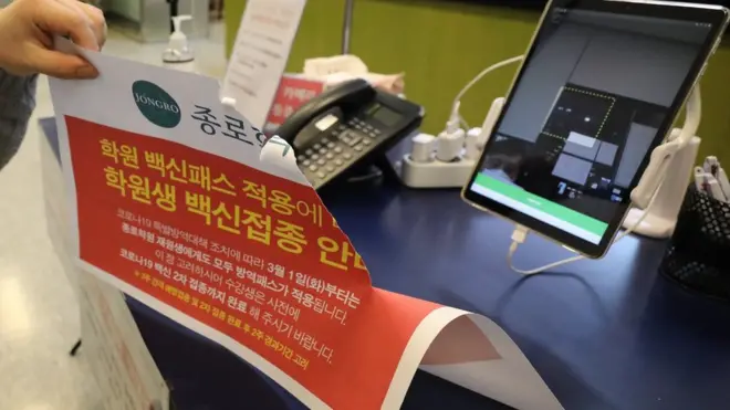 4일 오후 서울 마포구 종로학원 강북본원에서 관계자가 방역패스 관련 안내문을 떼고 있다