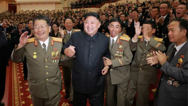 金正恩（中）在李洪燮（左）等军中干部簇拥下在平壤人民剧院内走动（朝中社2017年9月10日发放图片）