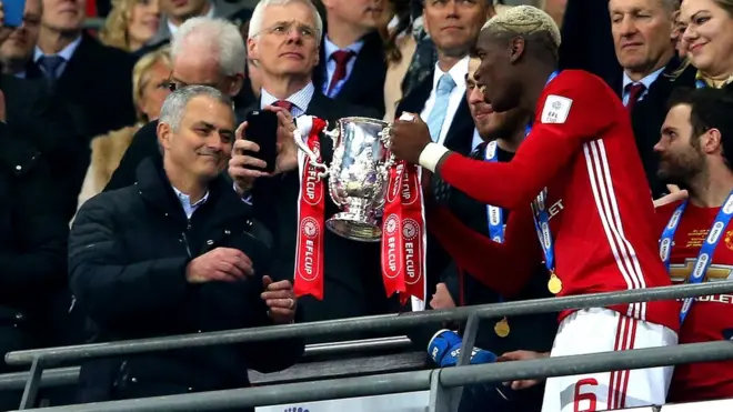 Жозе Моуринью получает Кубок английской лиги из рук футболиста своей команды Поля Погба