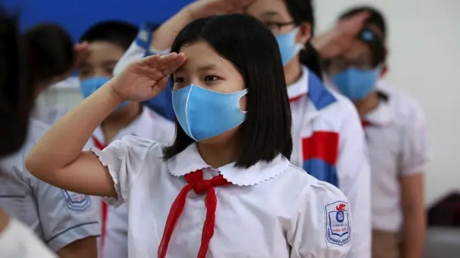 Children stand up for Vietnamese national anthem at their classroom at Phuc Dien elementary school Hanoi, Vietnam, 11 May 2020.