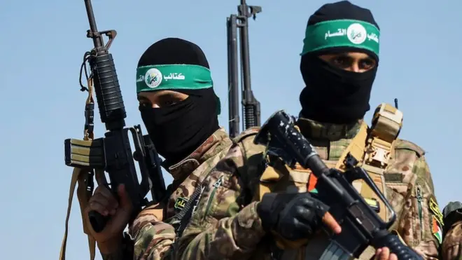 Palestinian fighters from the armed wing of Hamas take part in a military parade to mark the anniversary of the 2014 war with Israel, near the border in the central Gaza Strip on 19 July 2023
