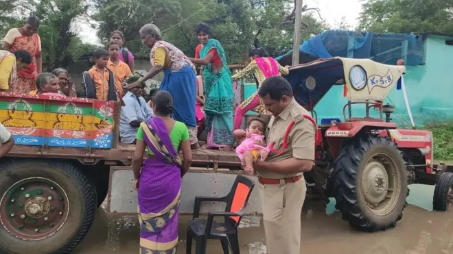 నెల్లూరు జిల్లా ఆత్మకూరు మండలంలో వరదలలో చిక్కుకున్నవారిని సురక్షిత ప్రాంతాలకు తరలిస్తున్న పోలీసులు