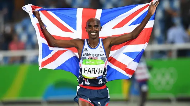 Mo Farah membawa bendera Inggris saat merayakan medali emas untuk 5000 meter di Olimpiade Rio 2016.