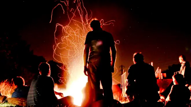 People gathered around a camp fire