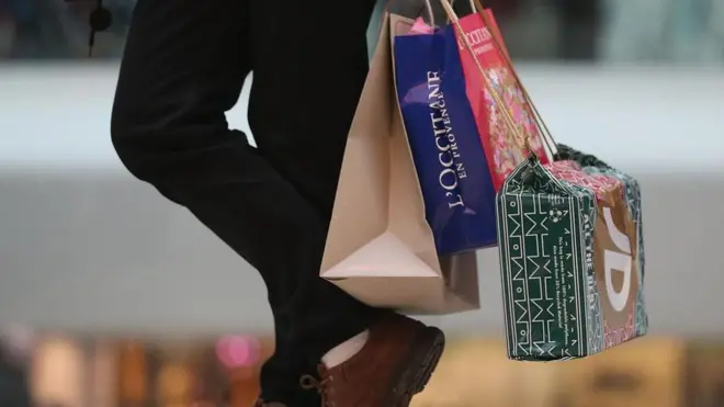 Homem segurando sacolas de compras