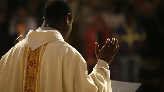 Catholic priest wey dey pray