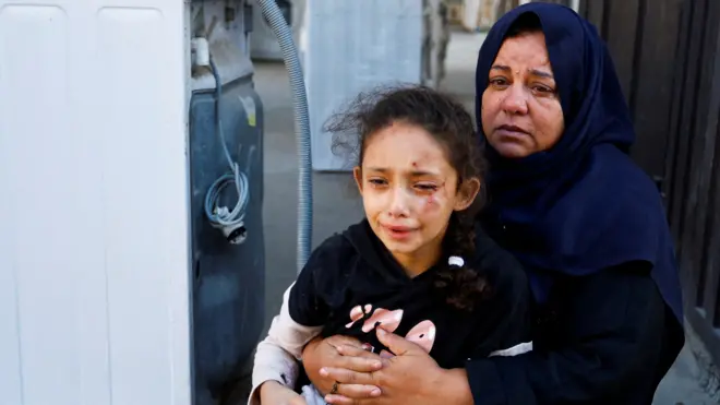加沙汗尤尼斯一位在以军空袭中受伤女孩在母亲怀抱中哭泣（12/10/2023）