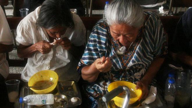 Venezuelans eating food provided by church volunteers
