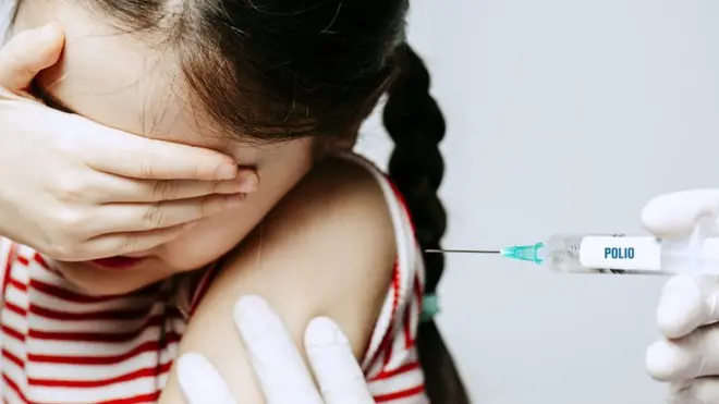 Una niña siendo vacunada contra la polio