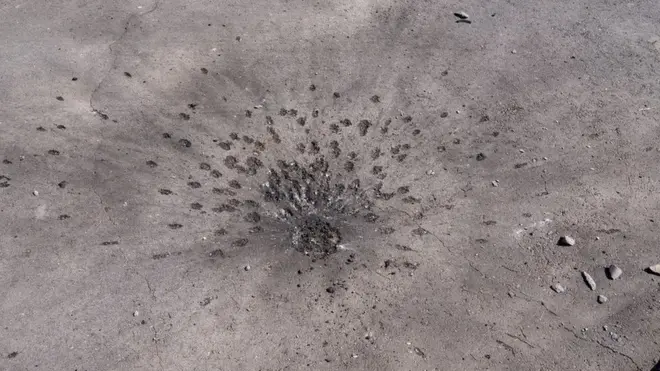 An apparent submunition impact from a cluster bomb in a Kharkiv residential neighbourhood (Joel Gunter/BBC)