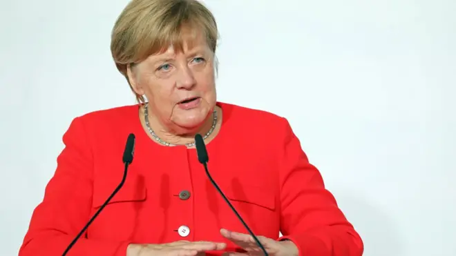 Almanya Başbakanı Angela Merkel oturarak konuşuyor
