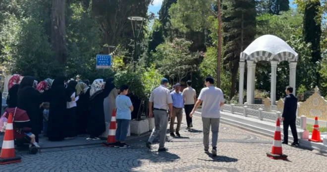 Bir mezarlığın etrafından kadınlar bir köşede, erkekler başka bir köşede toplanmışlar.