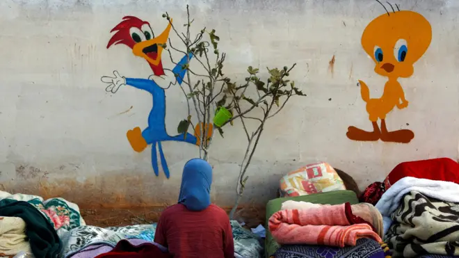 احدى الناجيات من الزلزال تجلس في ساحة مدرسة تحولت إلى ملجأ في قرية متضررة في 13 سبتمبر/أيلول 2023