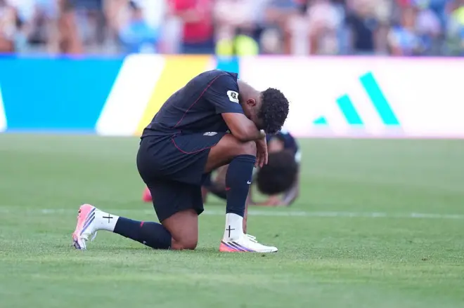 Jugador estadounindese de rodillas después de la derrota frente a Belgica.