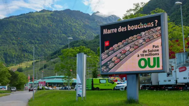 En Villeneuve, Suiza, el 13 de mayo de 2026, se observa un cartel antes de la votación del 14 de junio sobre un plan respaldado por el Partido Popular Suizo (SVP), de derecha, para limitar la población a 10 millones de habitantes. El cartel dice: "¡Hartos de los atascos! ¡No a una Suiza de 10 millones!".