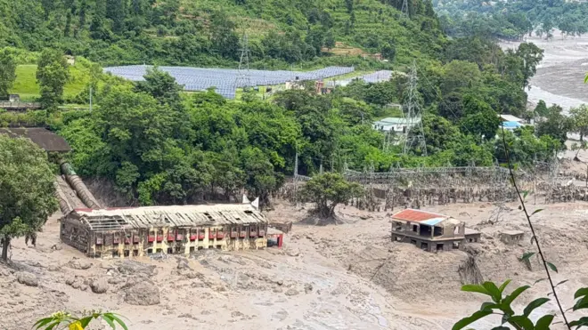 Mud and sand pile up against one hydropower plant wey dey affected by flash flood for northern Nepal