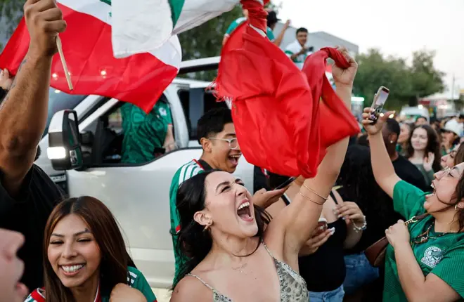 Mexicanos con la bandera celebran el triunfo de su selección. 
