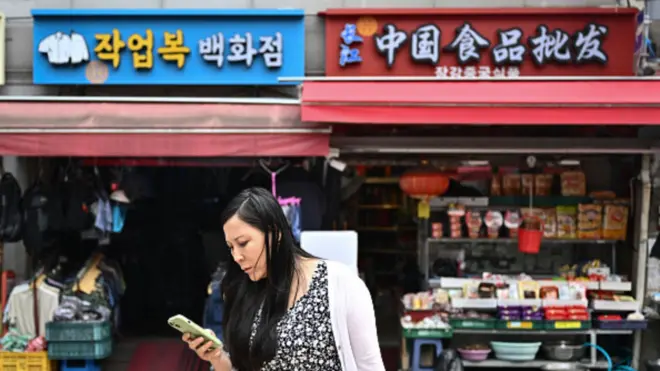 韓國首爾大林中國城街頭,一名華裔女性正在看手機