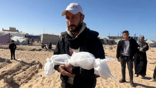 أب يحمل جثة طفله