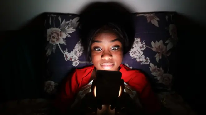 ስልኳን እየተመለከተች ያለች ግለሰብ