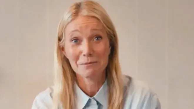 Gwyneth Paltrow appearing in a promotional video for Astronomer. She is wearing a light blue shirt and her loose, blonde hair fall below her shoulders.