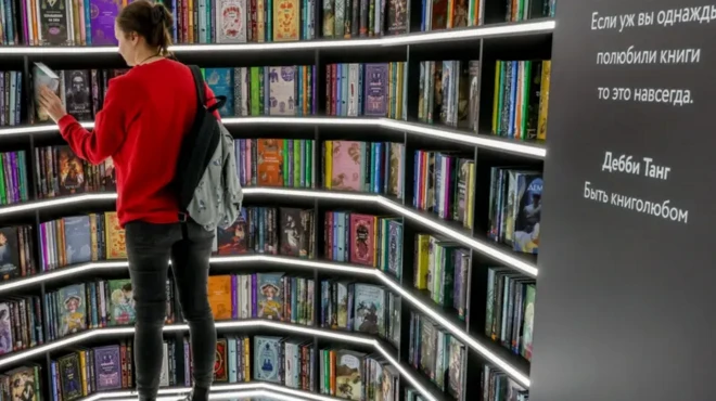 زنی در یک کتابفرشی کتابی انتخاب می‌کند