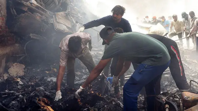 Autoridades de resgate trabalham no local onde o voo 171 da Air India caiu em uma área residencial perto do aeroporto de Ahmedabad em 12 de junho de 2025