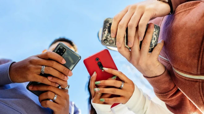 أشخاص يمسكون هواتف ذكية 