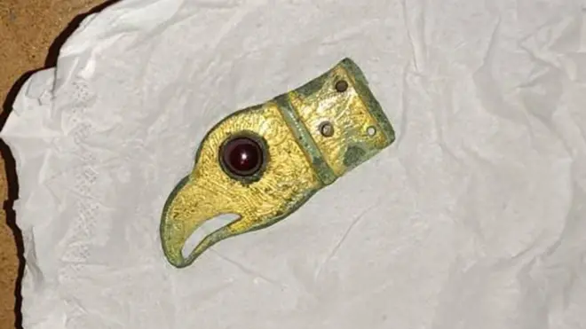 Фрагмент ременя у вигляді голови хижого птаха, датований IV-V століття