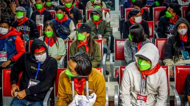 विमानतळावर बसलेले काही लोक