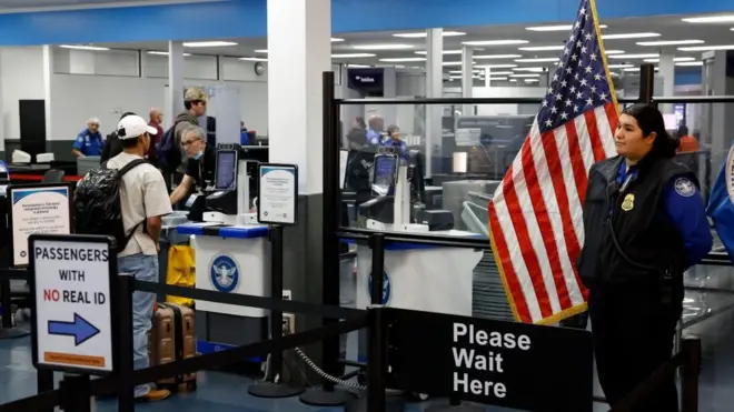 A Transportation Security Administration employee waits at a security checkpoint at the Hollywood Burbank Airport in Burbank, California