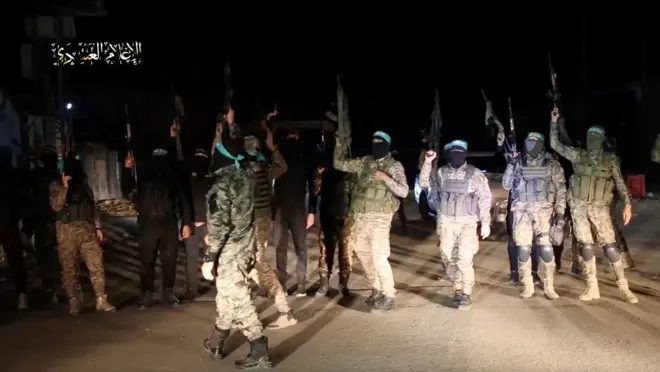 Dagaalyahanada Xamaas oo dabaaldageysa ka dib markii ay ku wareejiyeen la-haysteyaal ay qabsadeen rag hubaysan oo Xamaas ah intii lagu guda jiray weerarkii 7-dii Oktoobar ee Israa'iil.