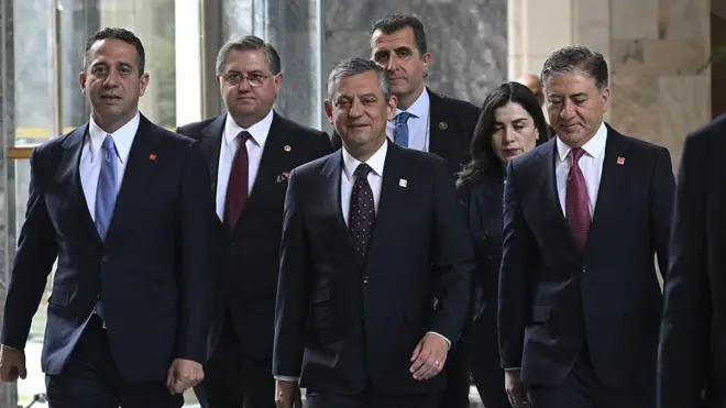 Özgür Özel ortada, çevresinde CHP'li önde gelen isimler var. Hepsinin üzerinde koyu renklerde takım elbiseler var, TBMM'de yürüyorlar. 