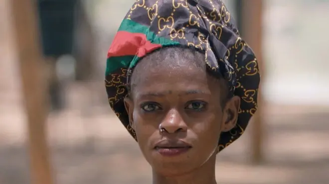 Isata, regardant droit dans l'objectif de la caméra