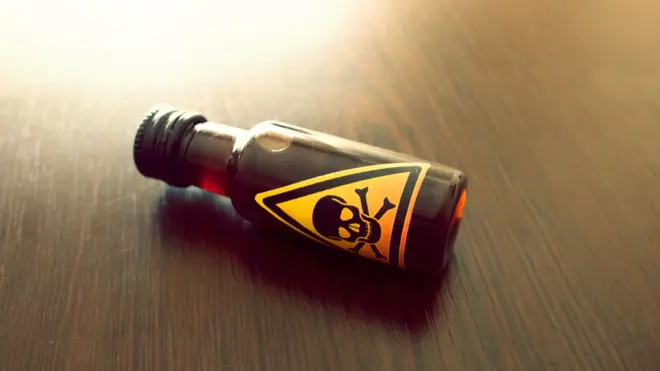 small bottle of poison with a yellow toxic sign represented by a skull and two bones icon in a triangle