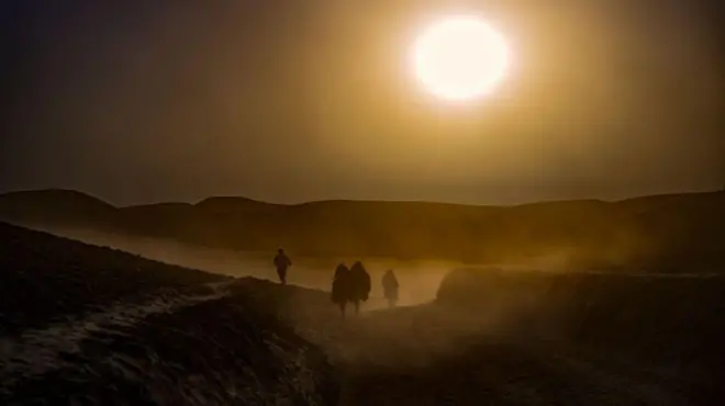 Afghans walk through the drought-hit countryside in October 2023