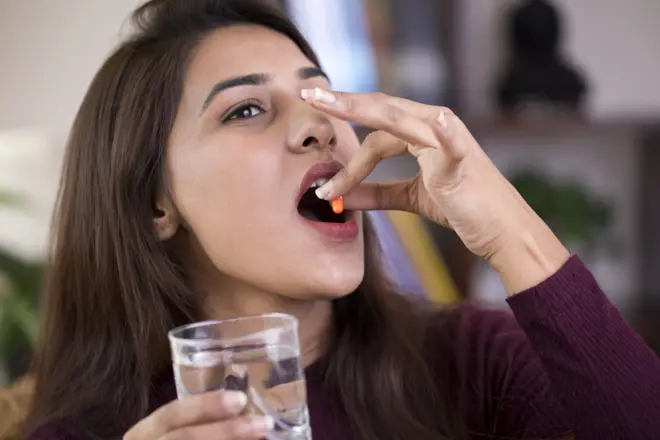 गर्भनिरोधक गोळी घेताना महिला 