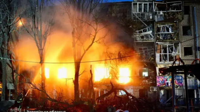 Вогонь у вікнах кількох квартир пʼятиповерхового цегляного будинку. Сусідні балкони розтрощені, рятувальники гасять полумʼя