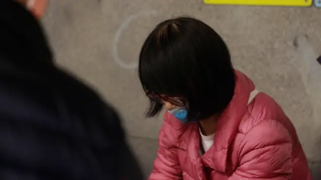 前女性無家者笑興正在分發給予露宿者的食物。(02/01/2025)