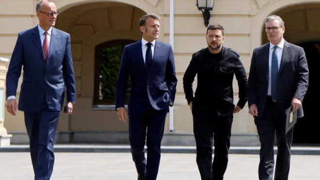 Umukuru wa reta y'Ubudagi Friedrich Merz, Perezida Emmanuel Macron w'Ubufaransa, Perezida Voloydmyr Zelensky wa Ukraine, hamwe n'umushikiranganji wa mbere w'Ubwongereza Keir Starmer bariko bagendagenda hanze y'ikirimba ca Mariynsky i Kyiv muri Ukraine.