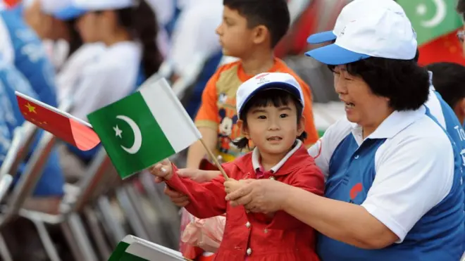 पाकिस्तान के ध्वज के साथ एक चीनी महिला