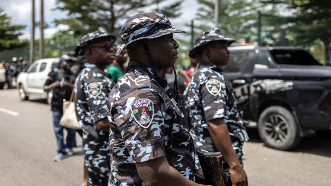 Àwọn ọlọ́pàá tó dúró ní àárín títì, wọ́n ń wo iwájú wọn