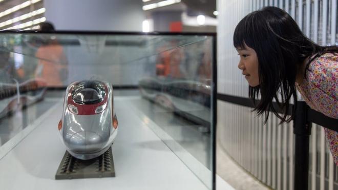 A girl looks at a model of the 'Vibrant Express' train on display at the West Kowloon terminus during an open day to the public in Hong Kong on September 1, 2018.