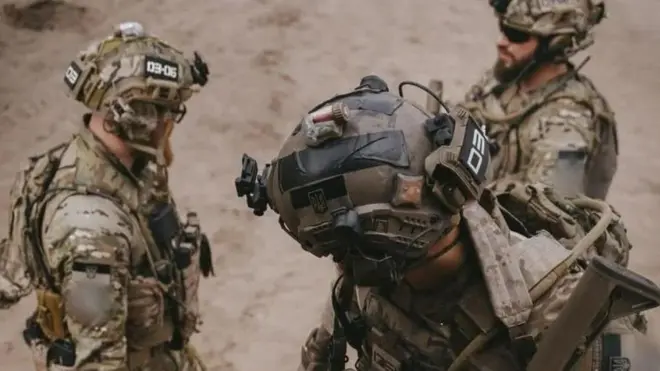 Військові стоять з амуніцією і зі зброєю в руках 